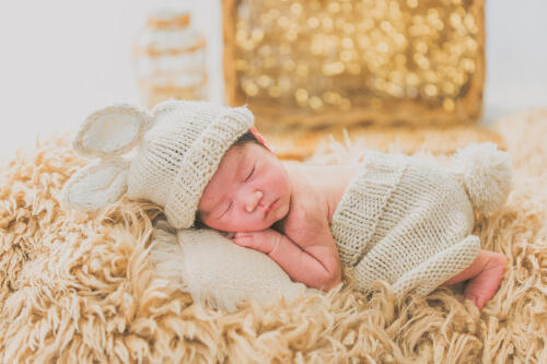 うさぎの帽子を被りうつ伏せで眠る新生児写真（撮影：しょうちゃん）