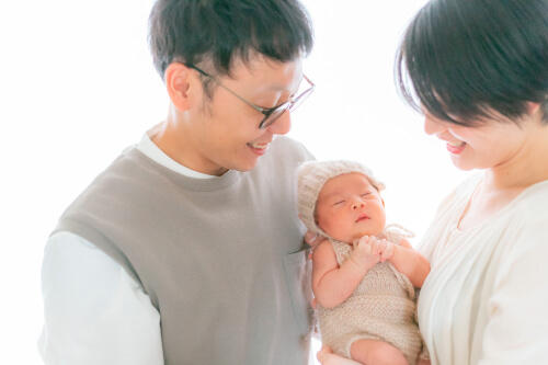 生後17日目の赤ちゃんを中心にお父さんとお母さんが笑顔で見守る様子を撮影したニューボーンフォト（撮影：のぐちまちこ（のぐちかめら））