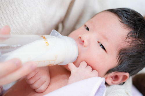 哺乳瓶のミルクを飲んでいる生後13日目の赤ちゃんの記念写真（撮影：NAZUphoto 森下なつ美）