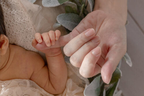 ママの小指をしっかり握る新生児の赤ちゃんの小さな手を撮影したニューボーンフォト（撮影：Muta Aya）