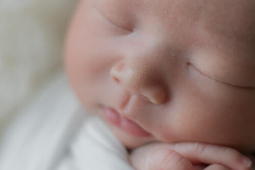 新生児のほっぺの肌感が分かるくらいアップで撮影したニューボーンフォト（撮影：すずきまりこ）