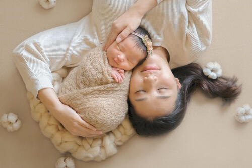 横になったお母さんと顔を寄せ合いながら眠る新生児を上から撮影したツーショット写真（撮影：ARIMI Style）