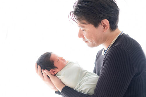 生後13日目の赤ちゃんを抱えるパパを横から撮影した写真（撮影：NAZUphoto 森下なつ美）
