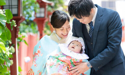 淡い水色の祝い着を着た赤ちゃんのお宮参りをしている家族の写真（撮影：青柳 理沙）
